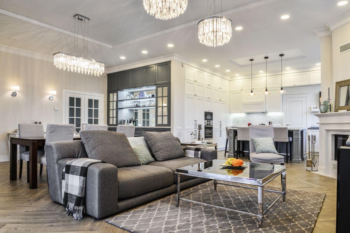 Living room interior in yellow and green colors features, gray sofa, fireplace, coffee table and  tv.